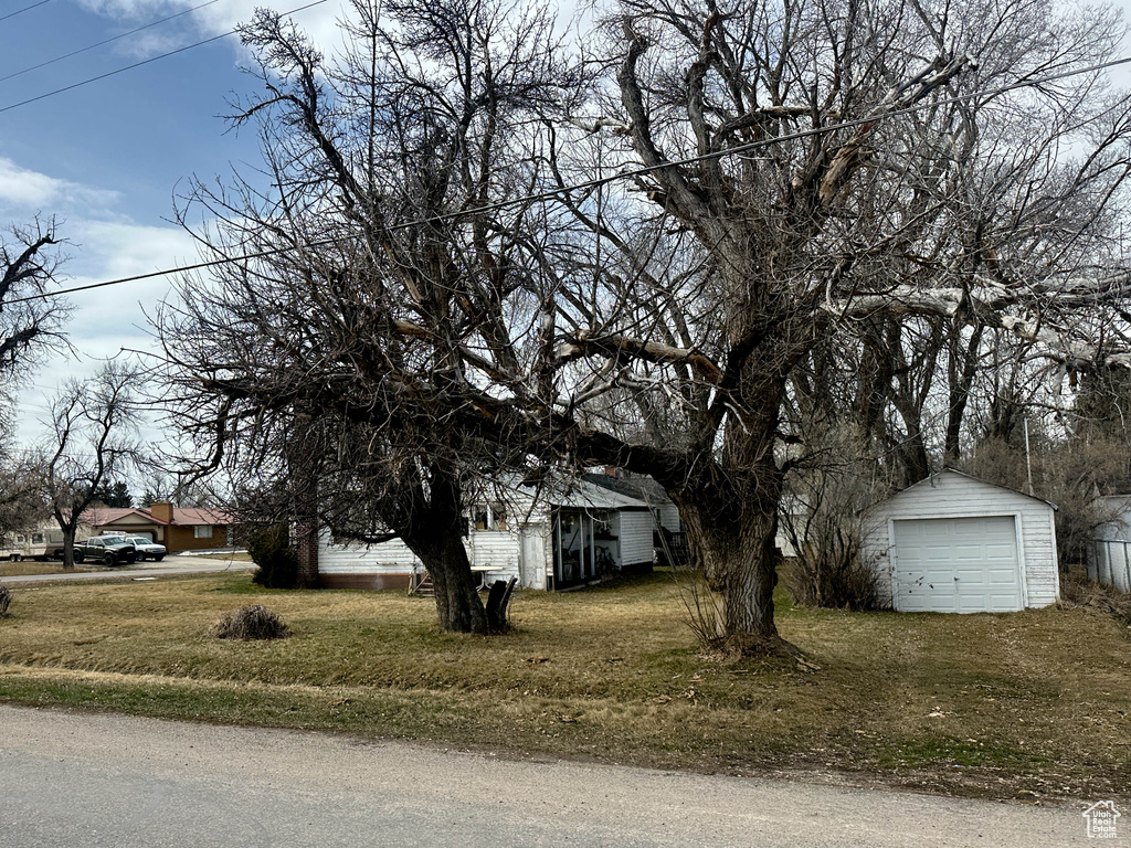 View of side of property with an outbuilding, a detached garage, and a yard