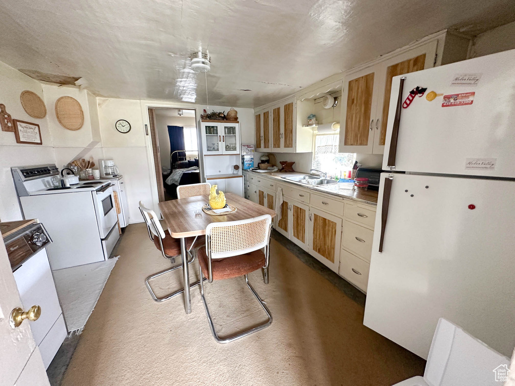 Kitchen with white appliances, a sink, and light countertops