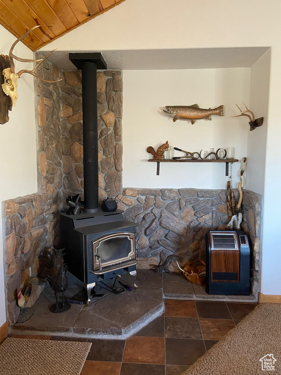 Detailed view of a wood stove, heating unit, wood ceiling, and baseboards