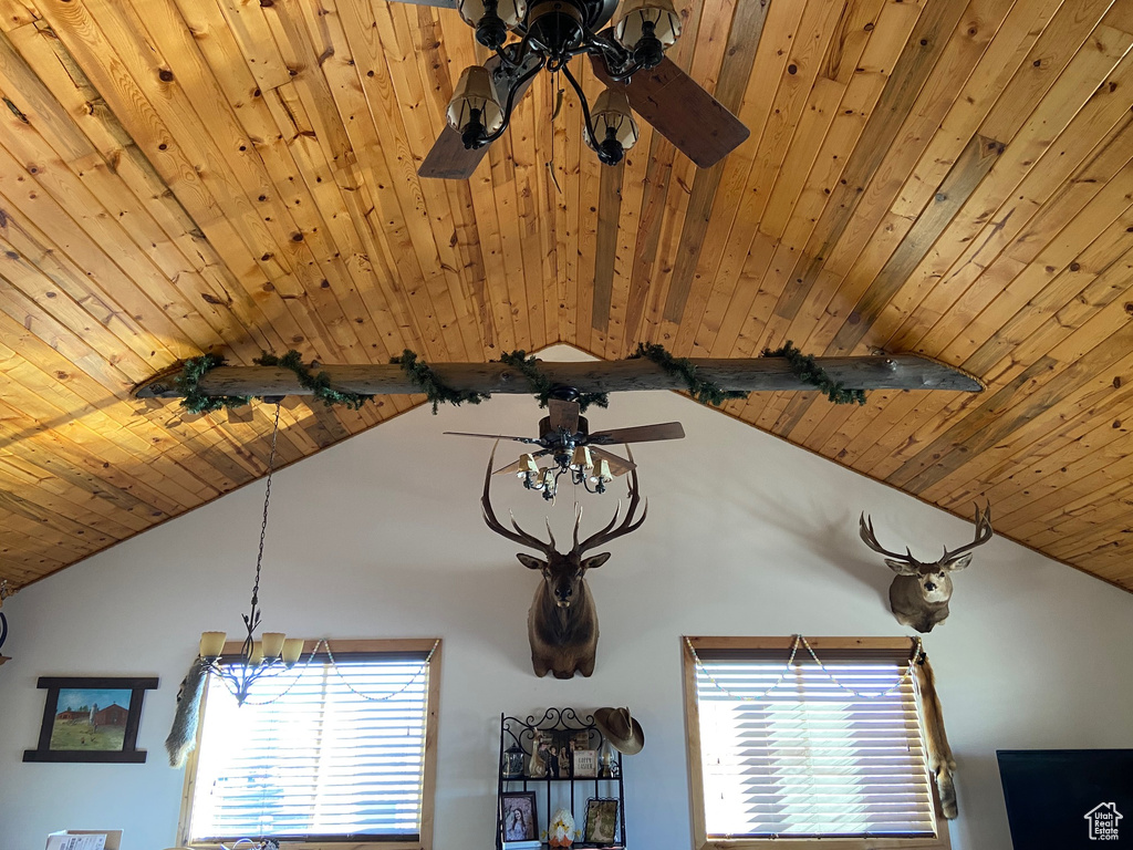 Detailed view of a ceiling fan, wood ceiling, and a chandelier