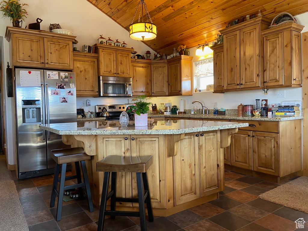 Kitchen with appliances with stainless steel finishes, wood ceiling, lofted ceiling, a center island, and decorative light fixtures