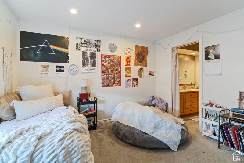 Bedroom featuring light colored carpet, recessed lighting, and connected bathroom