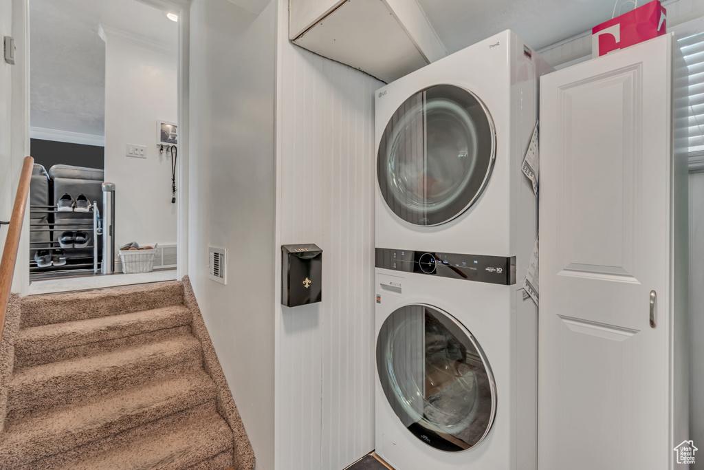 Washroom featuring stacked washer and clothes dryer