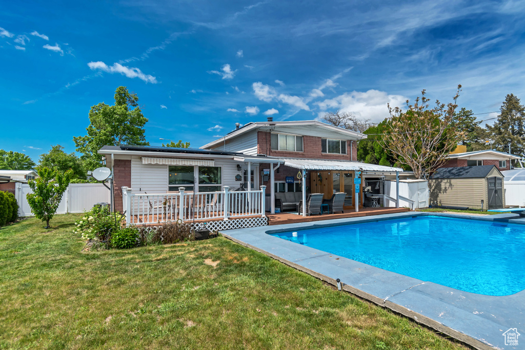 Rear view of house featuring a deck, a storage unit, an outdoor structure, and an outdoor living space