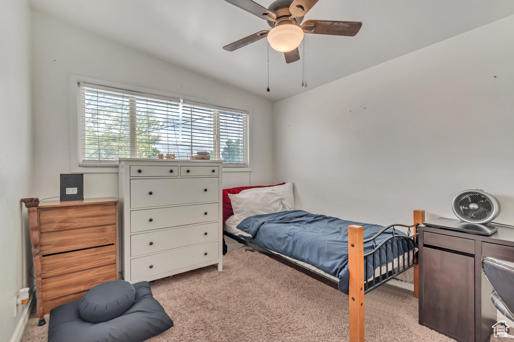 Bedroom with light carpet, vaulted ceiling, and a ceiling fan