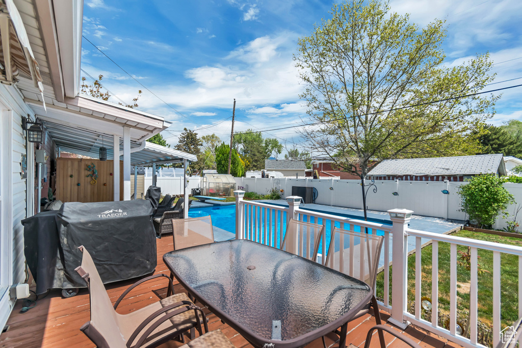 Wooden deck with a fenced backyard and outdoor dining space