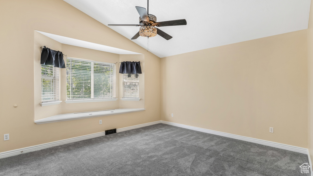 Unfurnished room with carpet floors, a ceiling fan, lofted ceiling, and baseboards