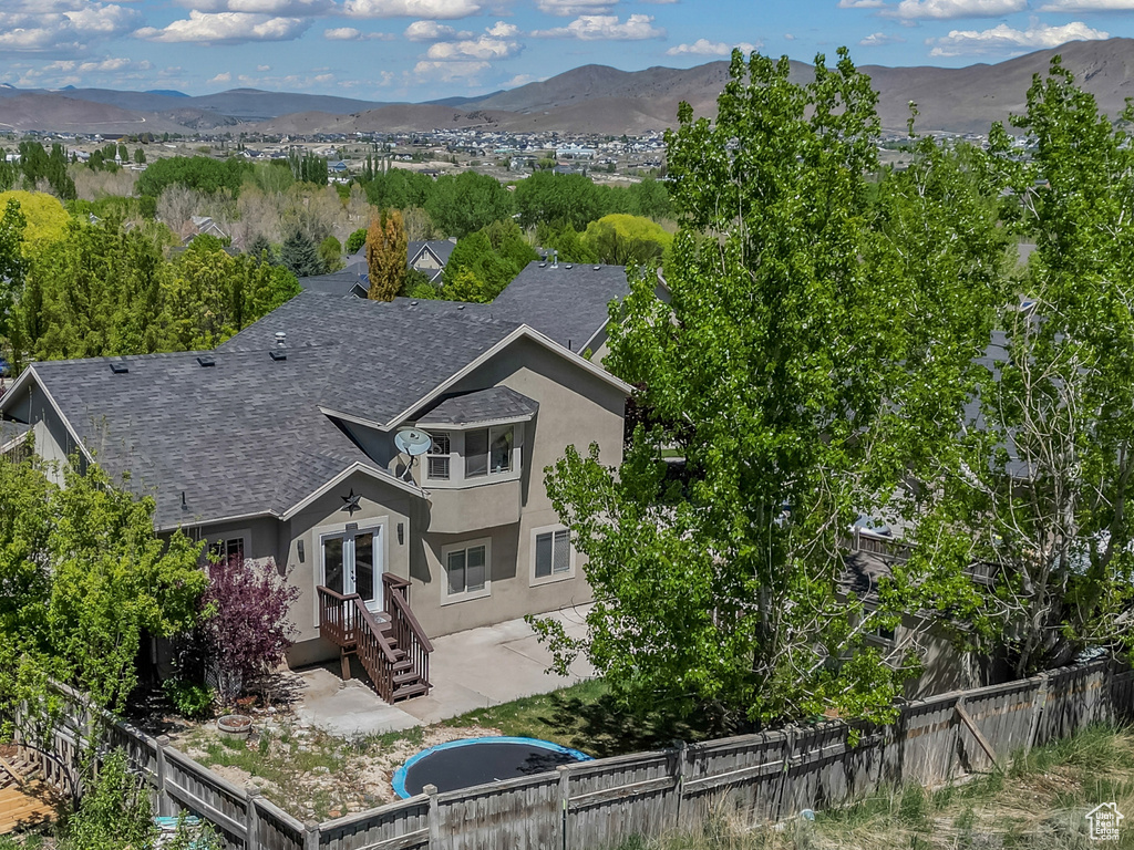 View of property exterior with a fenced backyard, stucco siding, a mountain view, and french doors