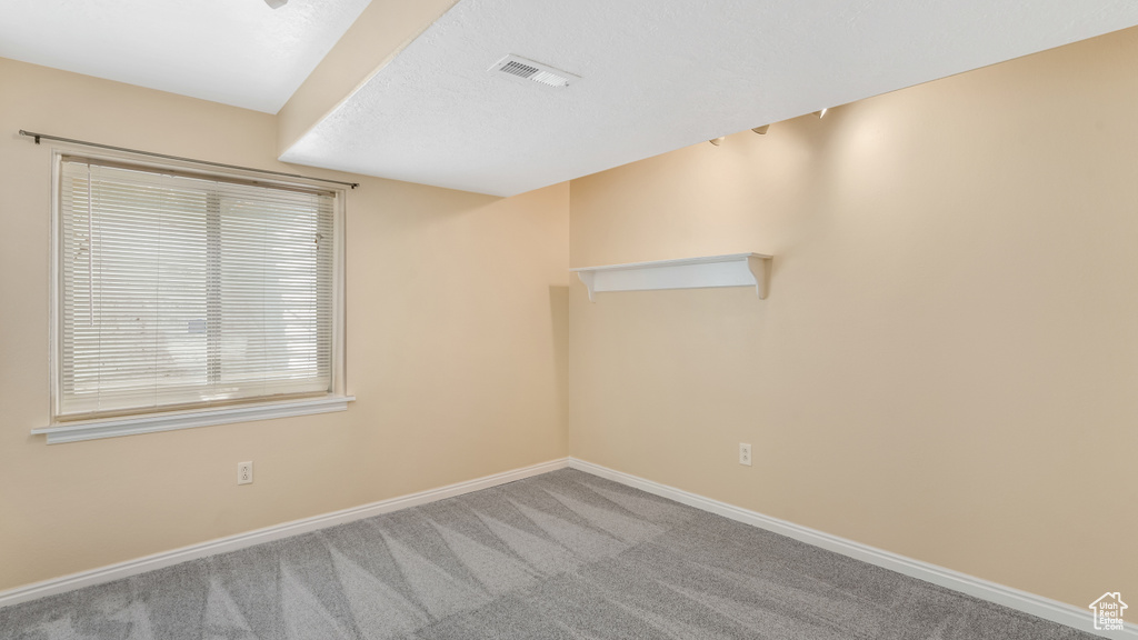 Carpeted empty room featuring baseboards