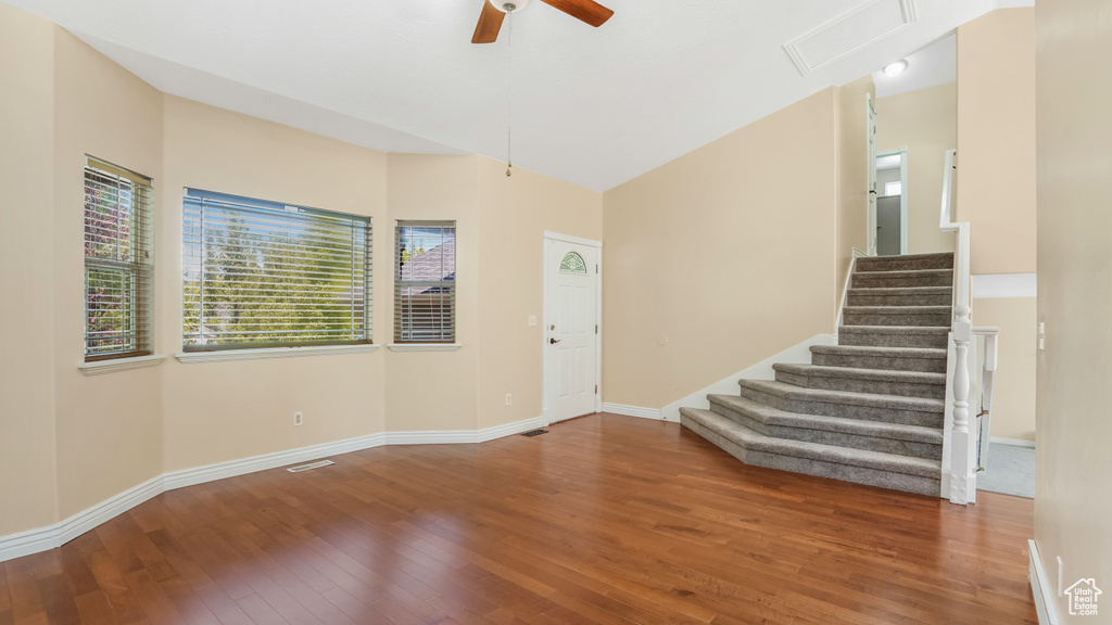 Foyer entrance featuring hardwood / wood-style flooring, a ceiling fan, stairs, and baseboards