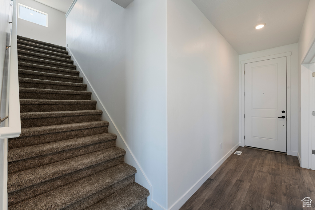 Staircase featuring wood finished floors, baseboards, and recessed lighting