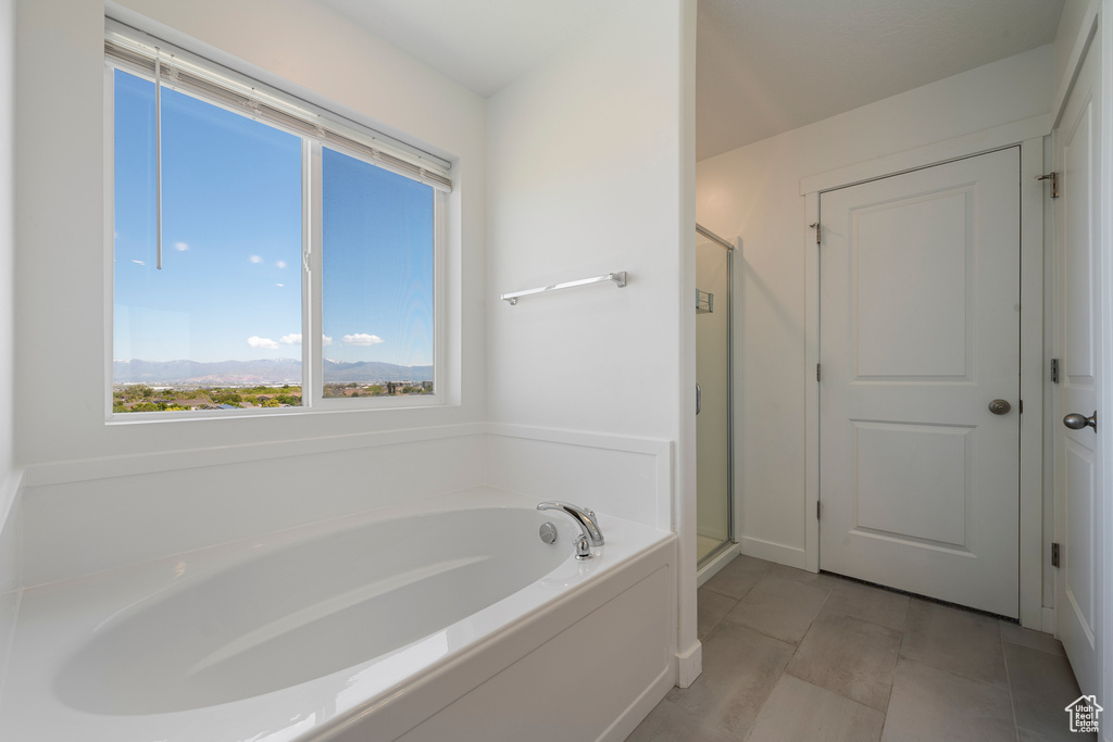 Bathroom featuring a garden tub and a shower stall