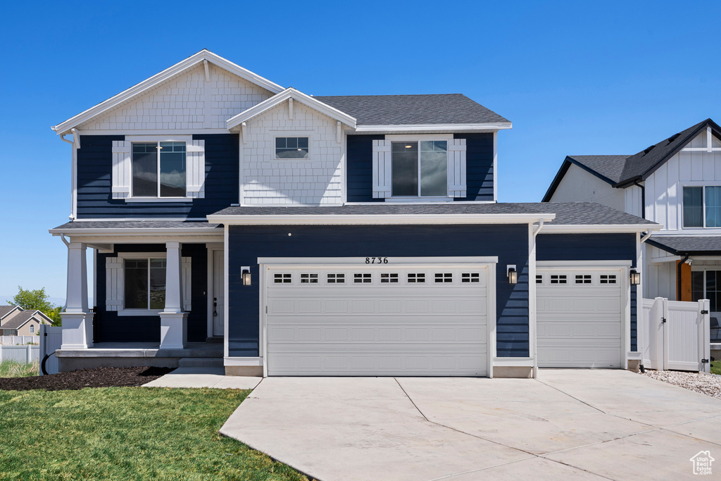 Craftsman-style house with covered porch, driveway, roof with shingles, and a garage