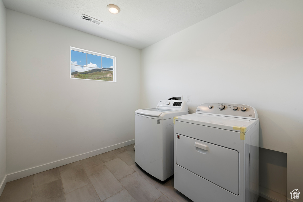 Laundry room with independent washer and dryer and baseboards