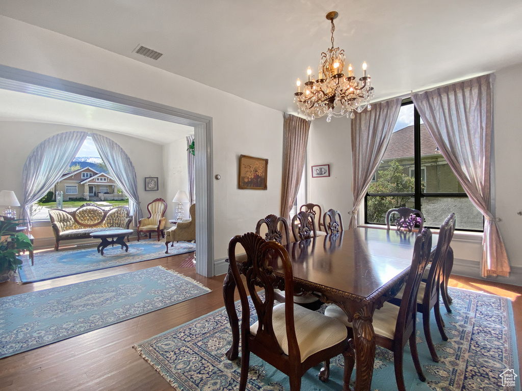 Dining space featuring a chandelier, wood finished floors, and baseboards