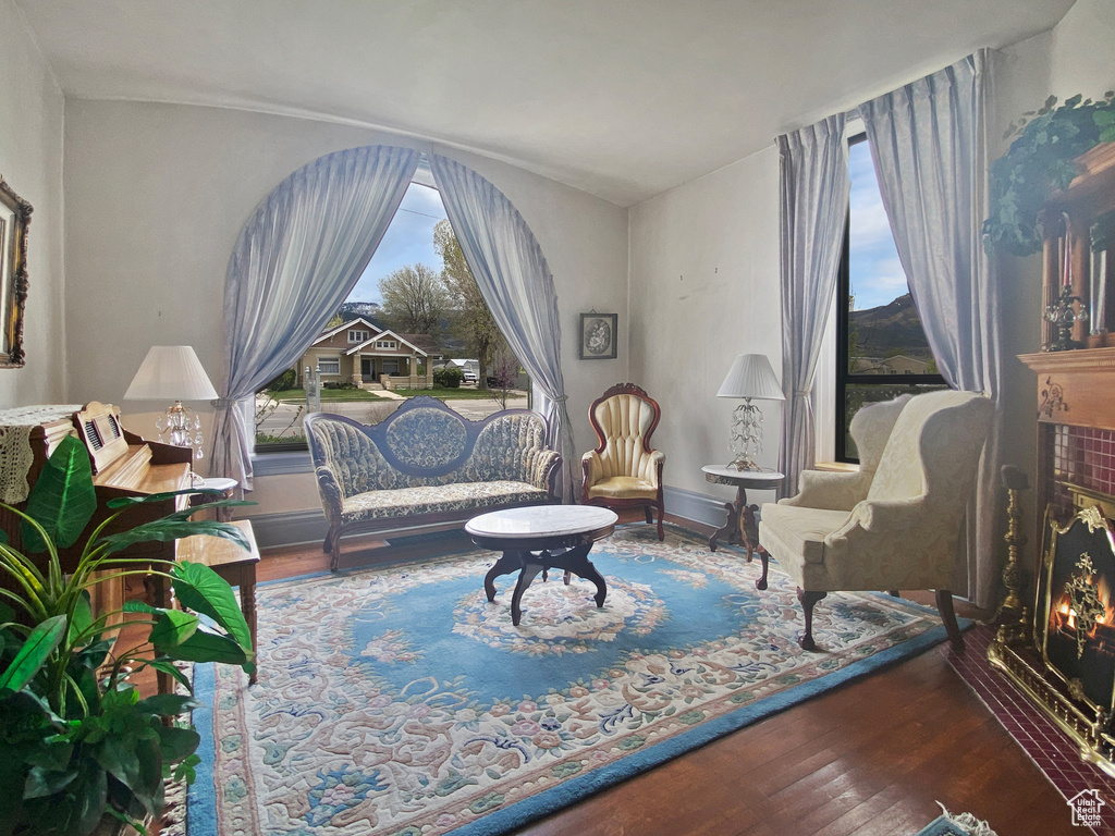 Sitting room featuring wood finished floors and a warm lit fireplace