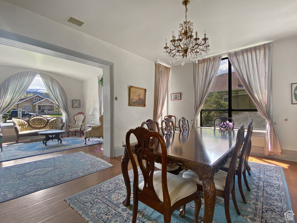 Dining space featuring a chandelier, wood finished floors, and baseboards