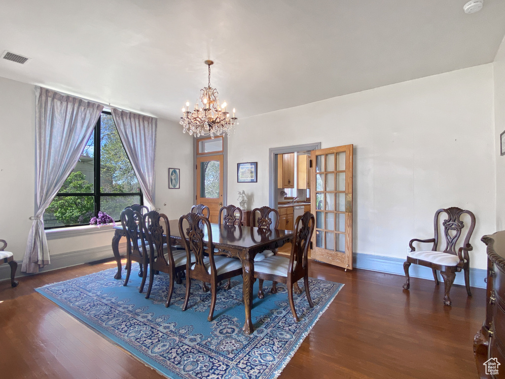 Dining space featuring a chandelier, wood finished floors, and baseboards