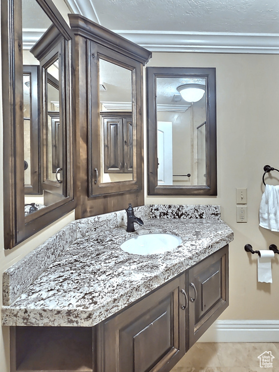 Bathroom with baseboards, vanity, and crown molding