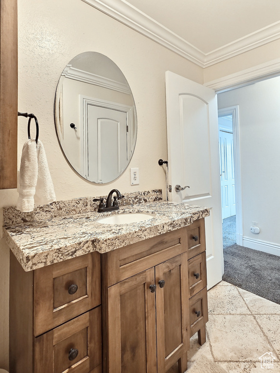 Bathroom featuring crown molding, vanity, and baseboards