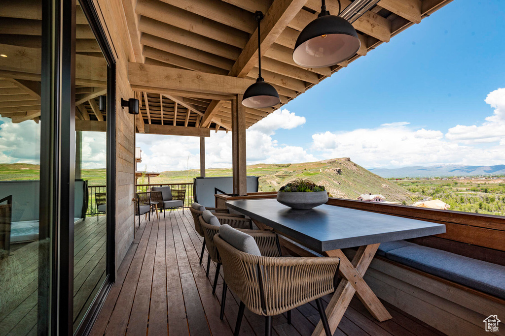 Deck with outdoor dining area and a mountain view