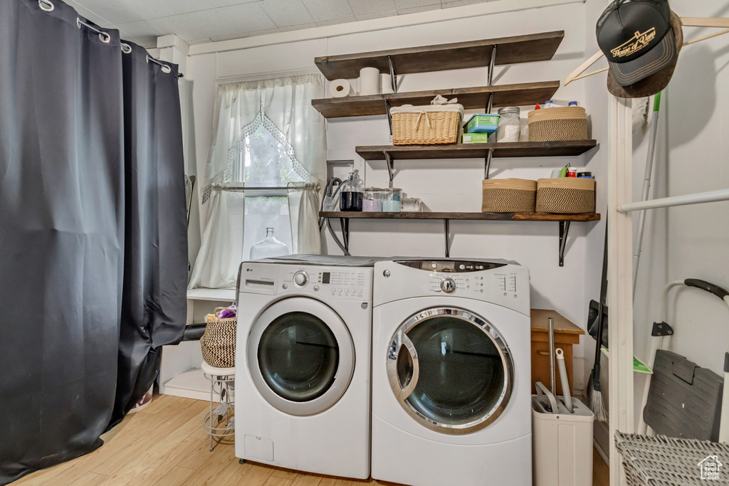 Washroom with separate washer and dryer and wood finished floors