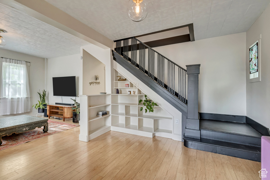Stairway featuring wood-type flooring and built in shelves