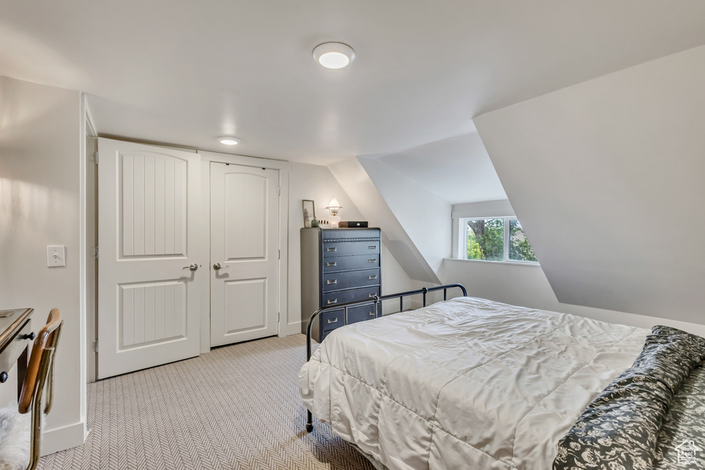 Bedroom featuring carpet flooring, baseboards, and lofted ceiling