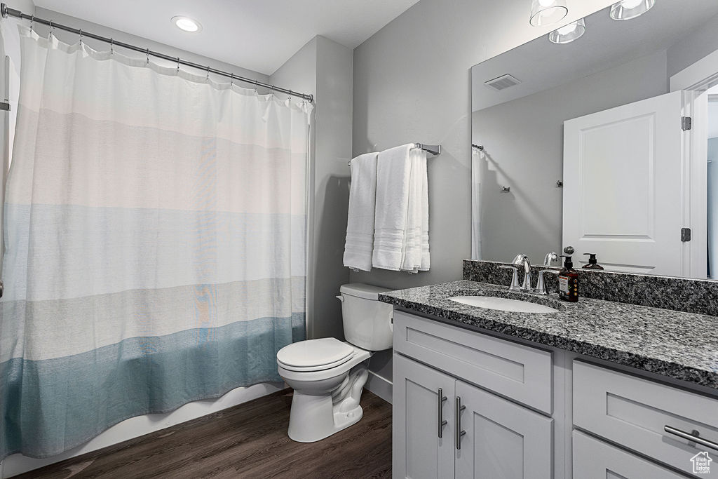 Full bath with wood finished floors, toilet, and vanity