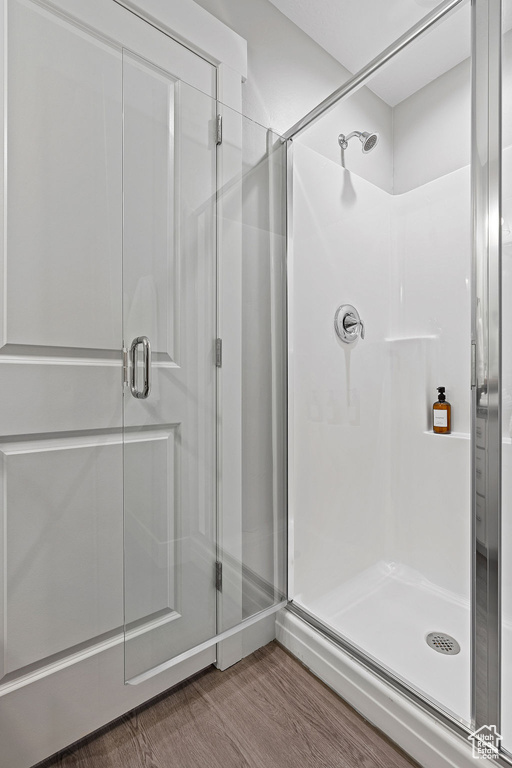 Bathroom with a stall shower and wood finished floors
