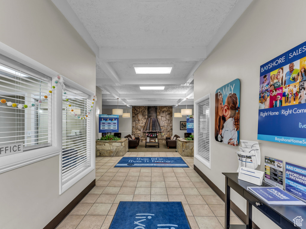 Hallway with tile patterned flooring, baseboards, and a textured ceiling