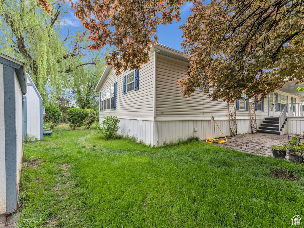 View of home's exterior with a yard and a patio