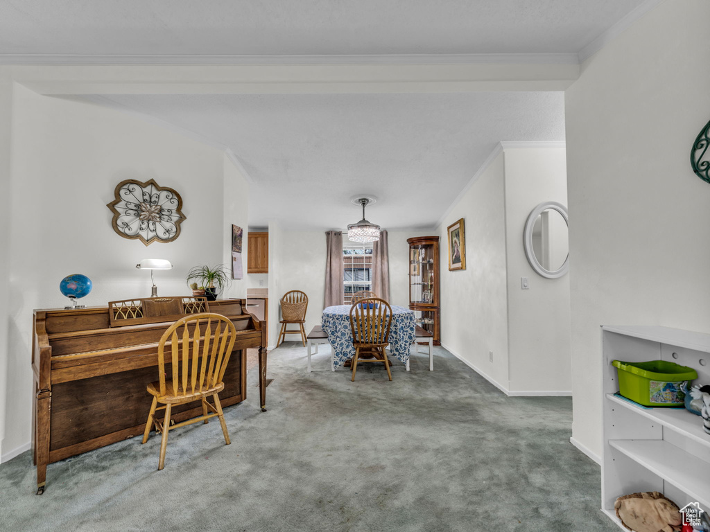 Carpeted dining room featuring ornamental molding, baseboards, and a desk
