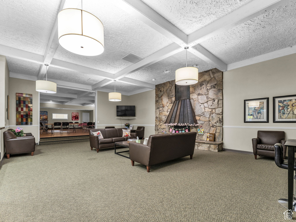 Living area with coffered ceiling, carpet floors, a textured ceiling, beamed ceiling, and baseboards