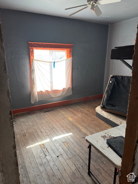 Unfurnished bedroom featuring baseboards, a ceiling fan, and hardwood / wood-style floors