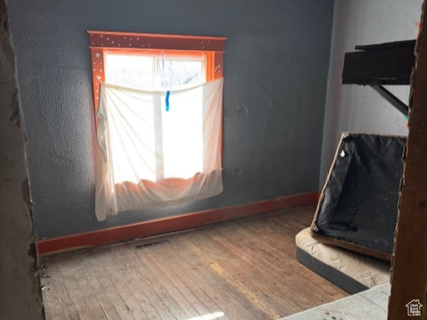 Unfurnished bedroom featuring baseboards, a ceiling fan, and hardwood / wood-style floors
