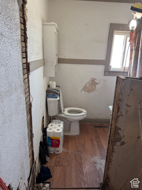 Bathroom with toilet and wood finished floors