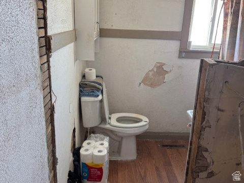 Bathroom with toilet and wood finished floors