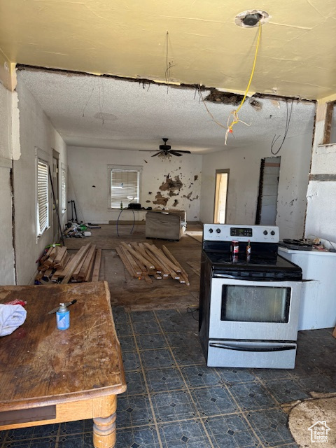 Kitchen with a ceiling fan, electric range, and open floor plan