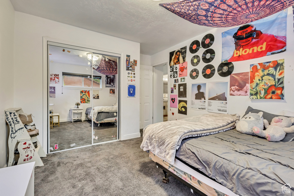 Carpeted bedroom with a closet and baseboards