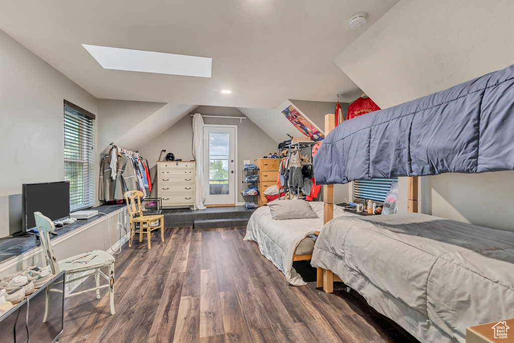 Bedroom with multiple windows, lofted ceiling with skylight, recessed lighting, and wood finished floors