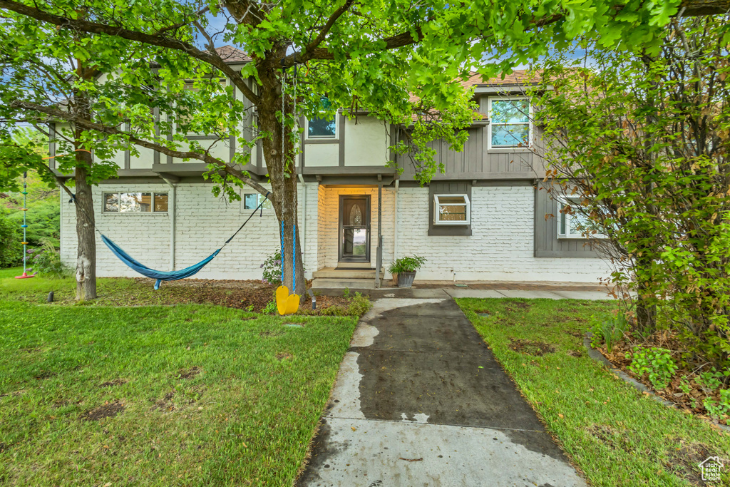 View of front of home with a front lawn and brick siding