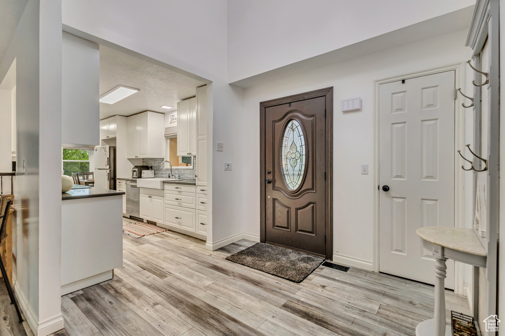 Foyer with baseboards and light wood finished floors