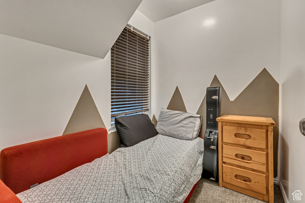 Carpeted bedroom featuring lofted ceiling