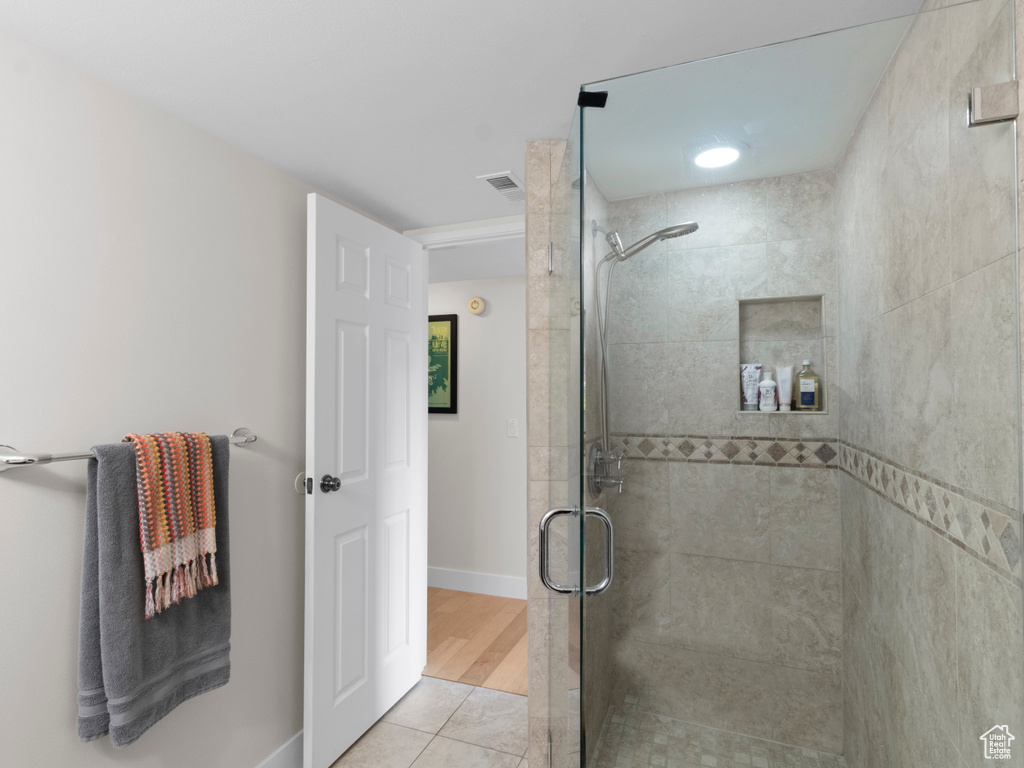 Full bathroom featuring a shower stall, tile patterned floors, and baseboards