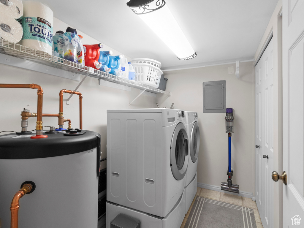 Laundry room featuring water heater, separate washer and dryer, light tile patterned floors, and electric panel