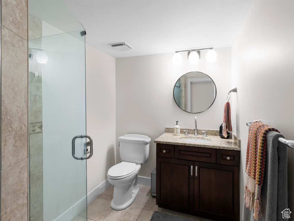 Bathroom featuring tile patterned floors, a shower stall, toilet, vanity, and baseboards