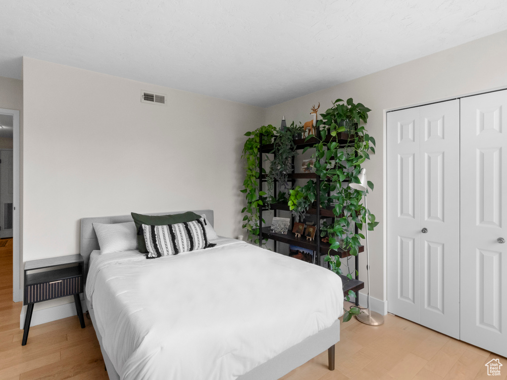 Bedroom with a closet, baseboards, and light wood-style floors