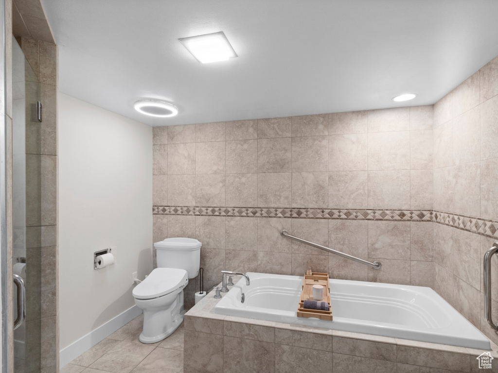 Full bath with toilet, tile patterned floors, a relaxing tiled tub, an enclosed shower, and tile walls