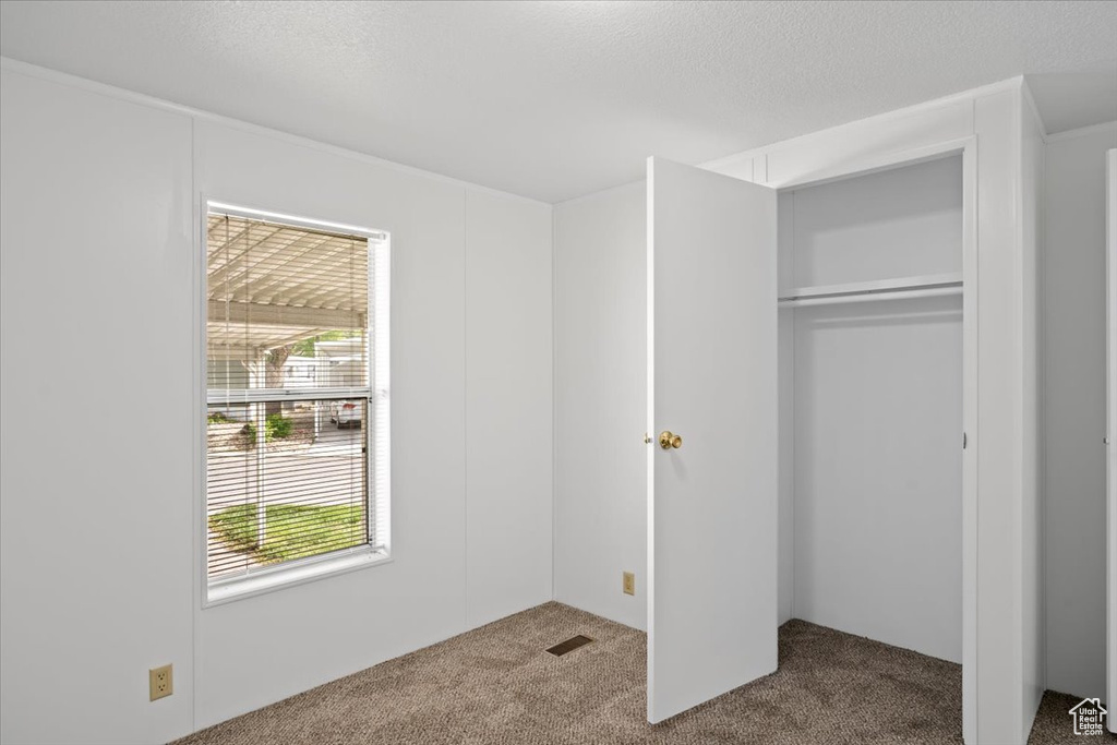 Unfurnished bedroom with carpet flooring and a closet